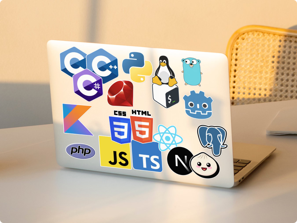 Laptop llena de stickers de logos de lenguajes de programación, frameworks, y tecnologías variadas